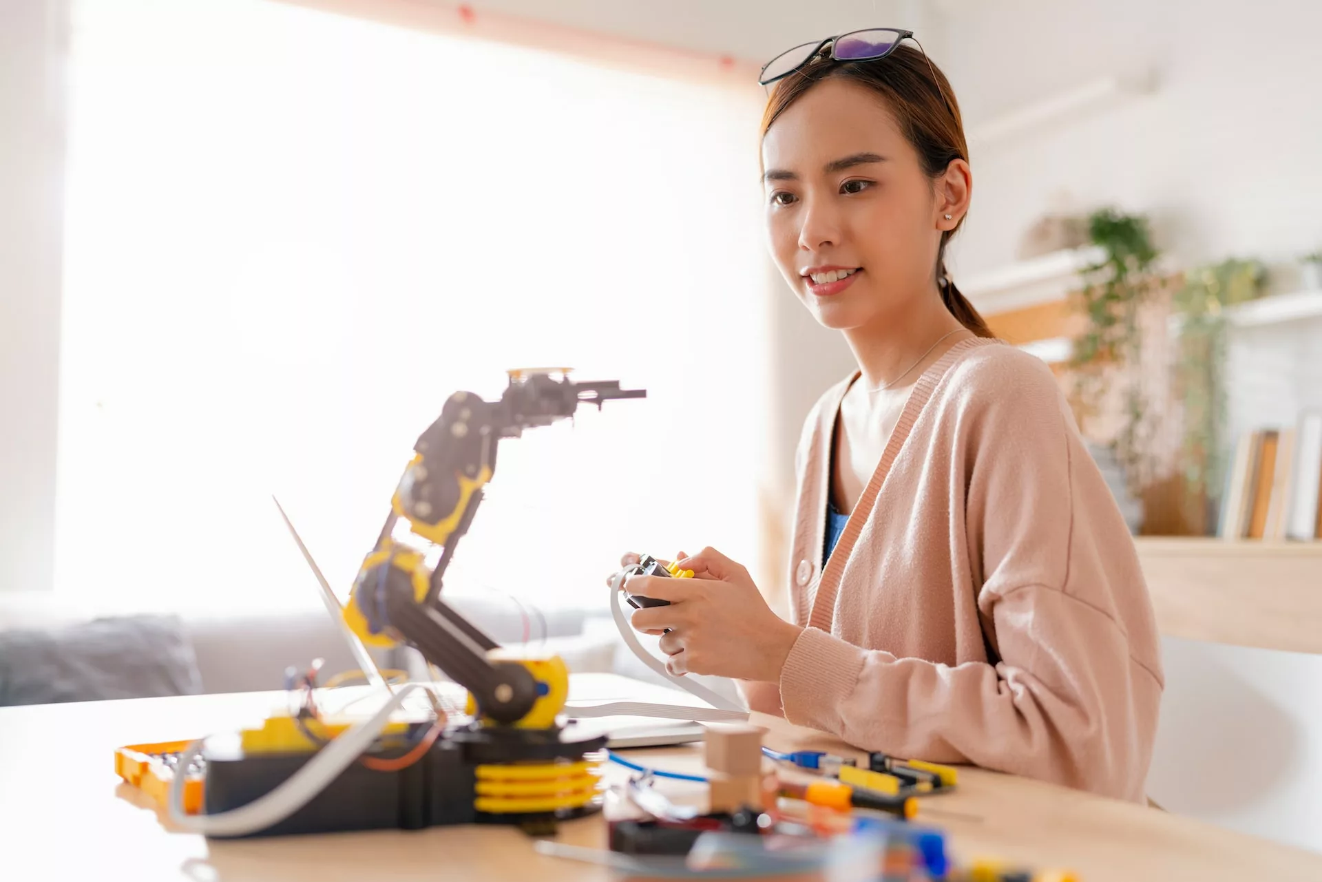 一名亞洲女性正在操作機器手臂